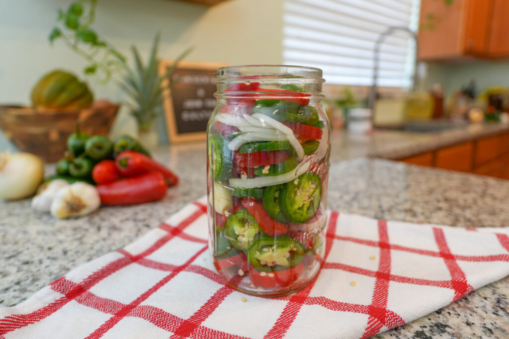 Fermented peppers filling jar